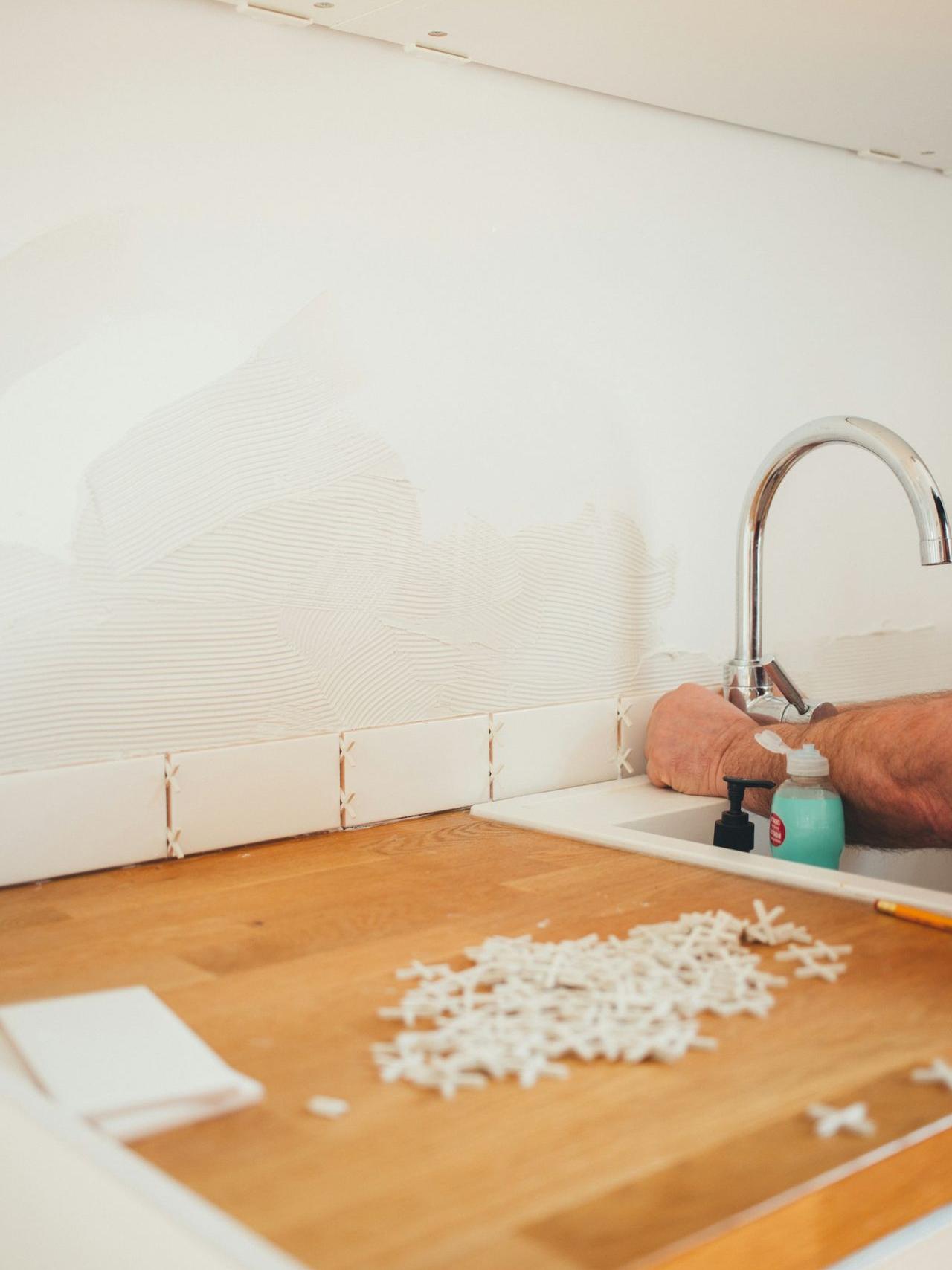 person holding gray curved faucet